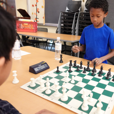 Central Library - Image of children playing chess in the Chess Club program
