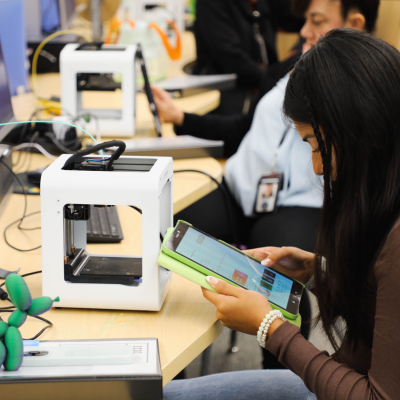 Haskett Branch Image of a patron using the 3D print machine.