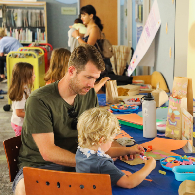 East Anaheim Branch - Image of a man assisting a child with crafts