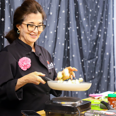 Image of a woman cooking with pan