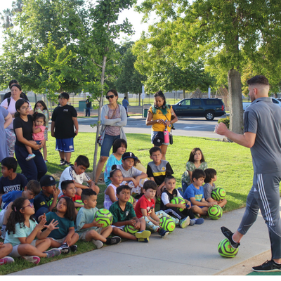Sunkist Branch image of OC soccer kicking a ball in front of children